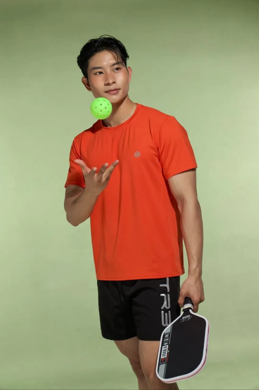 Người mẫu mặc áo thể thao DAILY màu cam chơi pickleball